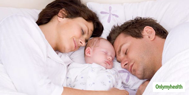 Newborn sleeping in bed with clearance parents