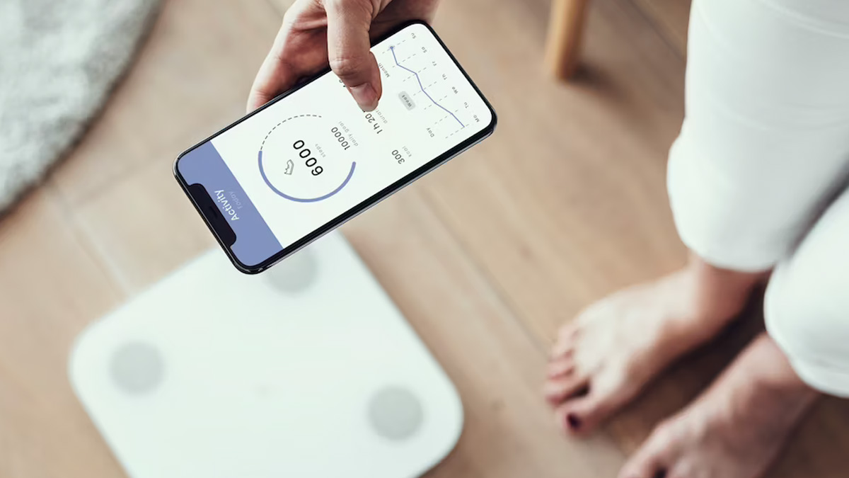 Woman foot takes a step onto a smart scale that makes bioelectric impedance  analysis, BIA, body fat measurements. Stock Photo