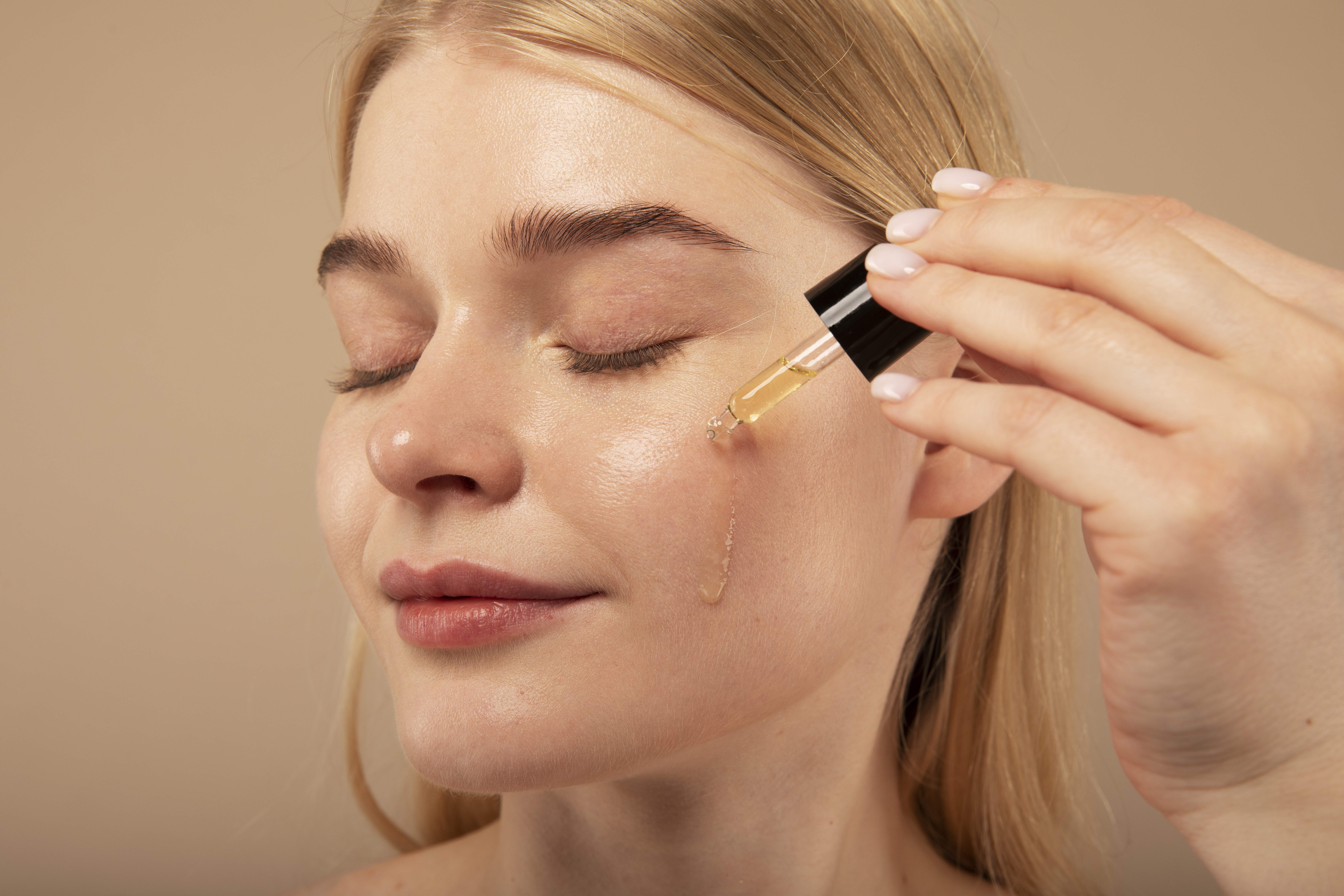 close-up-woman-applying-serum